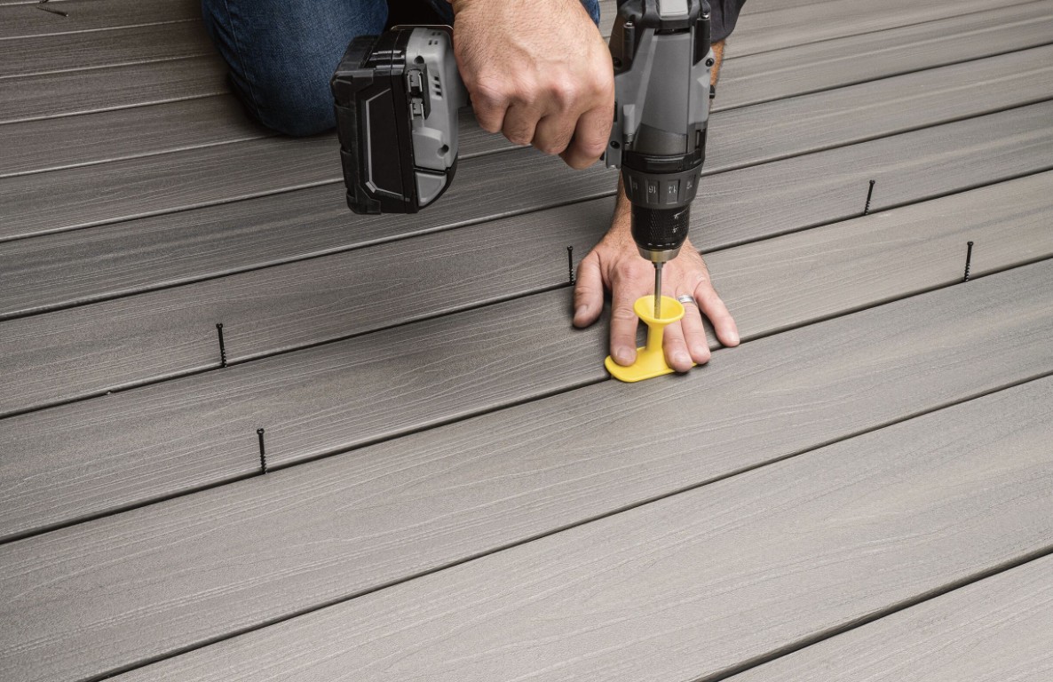 Professional deck builder installing composite decking with precision